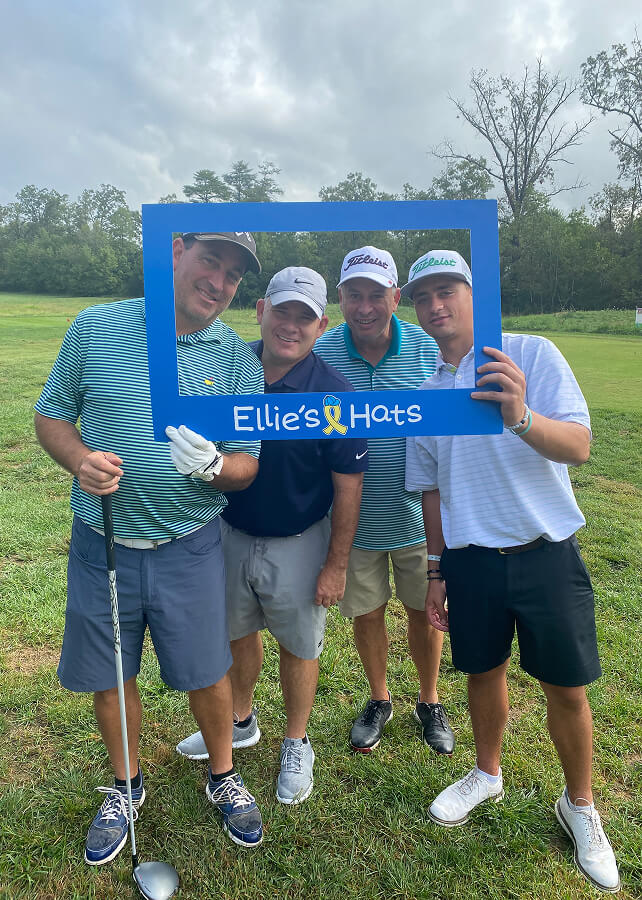 Foursome posing with the Ellie’s Hats photo frame on the course